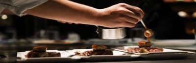 De laatste saus wordt met precisie over een bord geschept