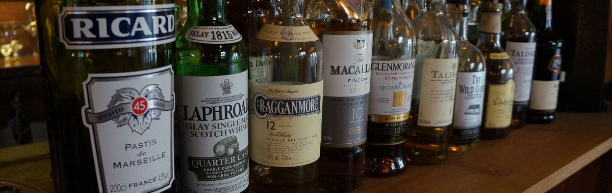 Een rij sterkedrank- en likeurflessen achter de bar van 't Drifke