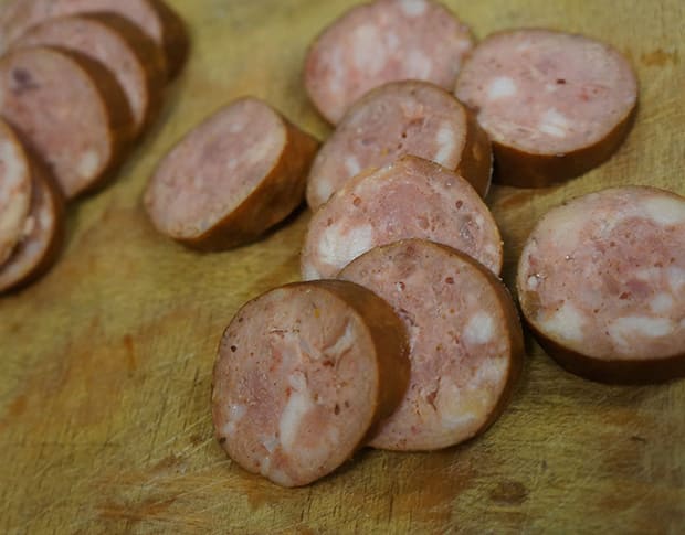 Vers gesneden rookworst op een houten snijplank